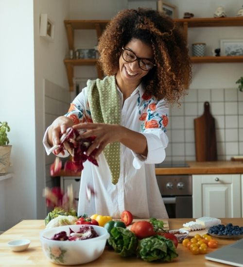 Healthy A woman preparing a healthy meal with fresh vegetables in her kitchen